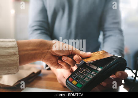 Pharmacien accepter carte de crédit de paiement sans contact. Femme de l'achat de produits dans la pharmacie. Pharmacien mains charge avec lecteur de carte de crédit Banque D'Images