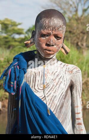 Surma fille avec la peinture du visage et du corps et de l'oreille, plaques, la vallée de la rivière Kibish Omo, Ethiopie, Afrique Banque D'Images