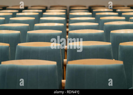 Fauteuil rembourré avec garniture verte. L'auditorium vide. Des chaises en bois. Banque D'Images