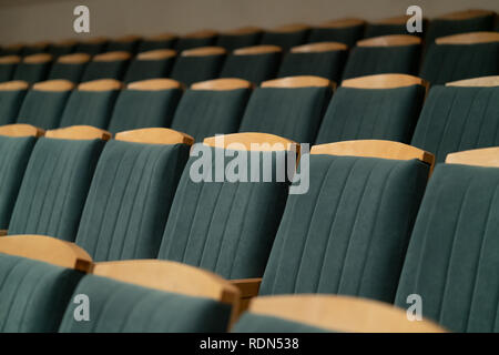 Fauteuil rembourré avec garniture verte. L'auditorium vide. Des chaises en bois. Banque D'Images