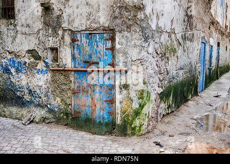 Un vieux porte bleue avec un bar pour la sécurité dans un quartier est situé à l'angle d'une rue dans le Mellah d'Essaouira en partie Morocc Banque D'Images