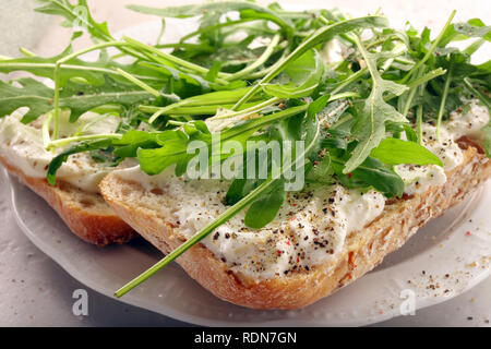 Sandwich frais et sain avec le fromage blanc et la roquette. Banque D'Images