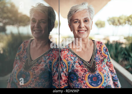 Portrait d'une belle femme d'âge moyen aux cheveux gris à la recherche dans l'appareil photo Banque D'Images