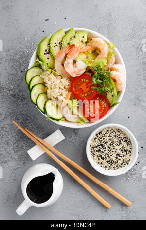 Hawaiian poke bol de crevettes, riz et légumes, bol Bouddha sain aux gambas, riz, avocat, concombre, tomate et laitue. Vue d'en haut Banque D'Images