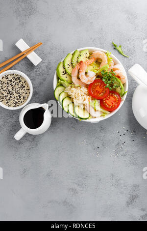 Hawaiian poke bol de crevettes, riz et légumes, bol Bouddha sain aux gambas, riz, avocat, concombre, tomate et laitue. Vue d'en haut Banque D'Images