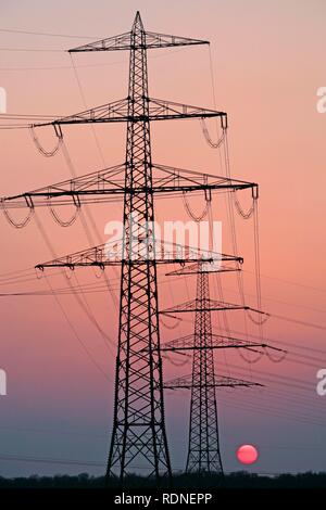 Pylônes électriques contre le coucher du soleil, Lunebourg, Basse-Saxe Banque D'Images