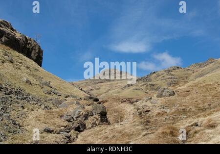 Large vallée entre crags : Ruisseau de montagne (Beck) entre les rochers et les landes herbeuses. Ciel bleu avec des nuages blancs, escarpés et plusieurs sommets de montagnes. Foo Banque D'Images