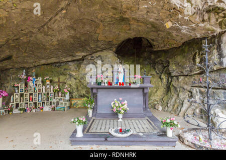 Petite chapelle dans une grotte naturelle avec la statuette de la Vierge de Lourdes et diverses statuettes religieuses à Vielsalm dans les Ardennes Belges Banque D'Images