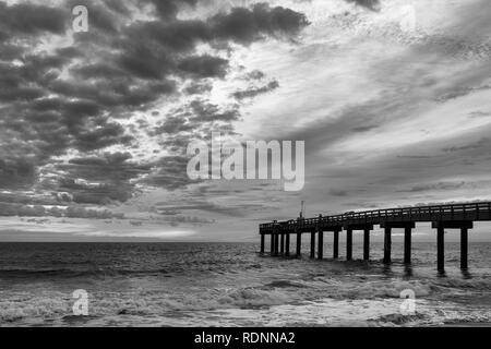 Lever du soleil en noir et blanc à la St Augustine Beach Pier, ou de Saint Johns County Ocean Pier, à Saint Augustine, Floride Banque D'Images