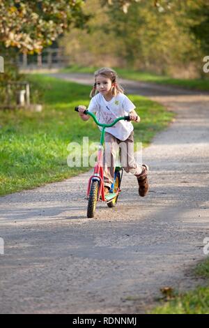 Petite fille sur un scooter Banque D'Images