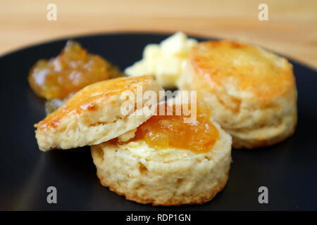 Fermé d'orange confites Marmelade scones avec confiture et beurre servi sur une plaque noire Banque D'Images