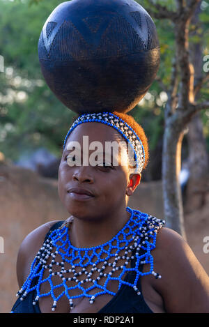 Fille d'équilibrage interprète zoulou pot bleu sur sa tête au Shakaland Zulu Cultural Village,Eshowe, KwaZulu-Natal, Afrique du Sud Banque D'Images