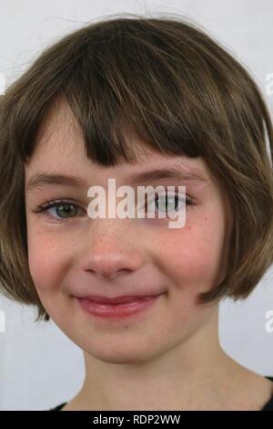 Portrait d'une jeune fille aux yeux verts avec un sourire espiègle Banque D'Images