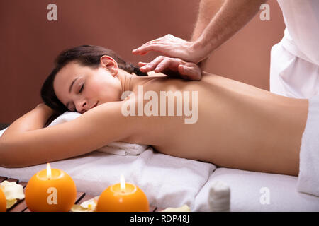 La main du thérapeute détendue de jeune femme à Spa Banque D'Images