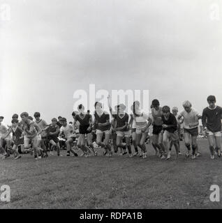 1967, historique, sports scolaires, un groupe de lycéens dans leurs kits de gym commençant une course à l'extérieur dans un domaine sportif, Angleterre, Royaume-Uni. Banque D'Images