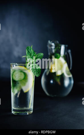 Boisson d'été frais. Une santé de verre d'eau minérale detox au citron, menthe, romarin et le concombre en pot Mason sur fond sombre. Concept d'aliments sains Banque D'Images