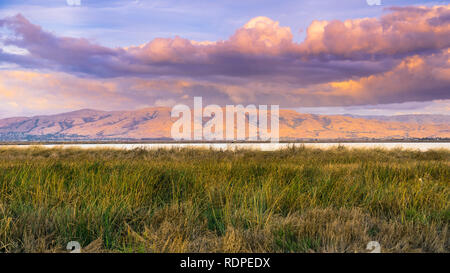 Paysage au coucher du soleil des marais du sud de la baie de San Francisco, Pic Mission couvert de nuages colorés au coucher du soleil dans l'arrière-plan, Sunnyvale, Californie Banque D'Images