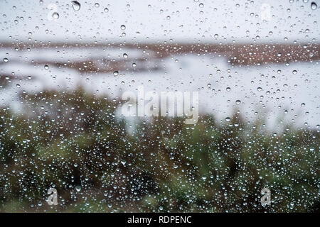 Gouttes de pluie sur la fenêtre sur un jour de pluie ; Marsh et des étangs dans la baie de San Francisco en arrière-plan ; Californie Banque D'Images