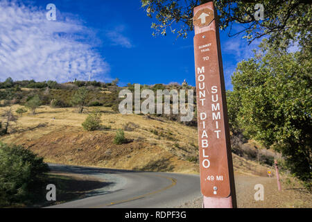 Posté signe sur le sentier de randonnée au Mont Diablo peak (visible en arrière-plan) à un endroit où le sentier croise la route, Mt Diablo State Park, Co Banque D'Images