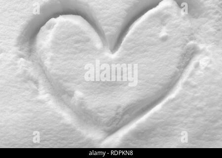 Forme de coeur symbole dessiné sur le blanc de la neige dans l'hiver froid Banque D'Images