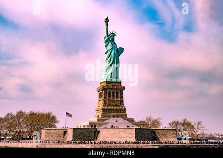 Statue de la liberté dans le milieu avec beaucoup de touristes autour d'elle avec pinky ciel nuageux avant le coucher du soleil Banque D'Images