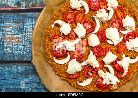 Pizza avec blat de patate douce et de graines d'avoine, garnie de champignons, oignons, mozzarella et tomates cerises Banque D'Images