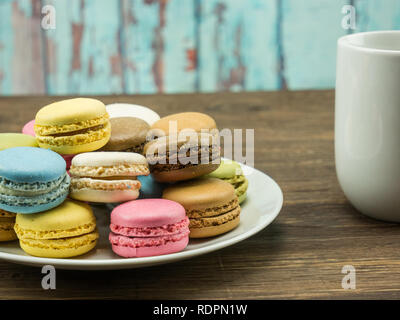 Assiette de macarons français côté de blanc tasse close up Banque D'Images