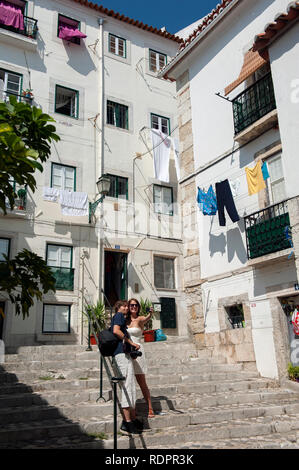 Un couple qui pose pour une photographie dans les petites rues de l'Alfama, Lisbonne, Portugal Banque D'Images