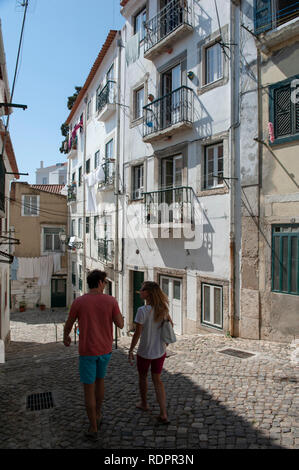Un couple en train de marcher dans les ruelles d'Alfama, Lisbonne, Portugal Banque D'Images