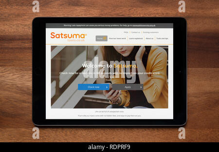 Le site web de Satsuma prêts est vu sur une tablette iPad, qui repose sur une table en bois (usage éditorial uniquement). Banque D'Images