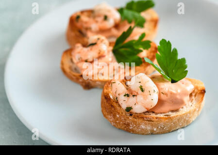 Bruschettas sandwiches aux crevettes, sauce crémeuse et le persil. Banque D'Images