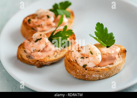 Bruschettas sandwiches aux crevettes, sauce crémeuse et le persil. Banque D'Images