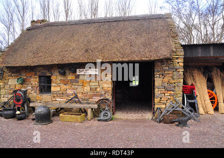 Le Kerry Bog Village Forge, avec toit de chaume et d'outils anciens, met en œuvre et à l'extérieur des pots de fer.le comté de Kerry, en République d'Irlande. Banque D'Images