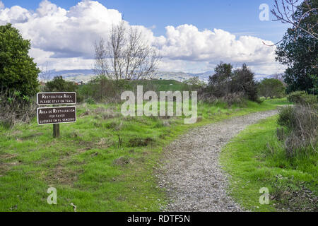 Posté affiche bilingue "Restauration Salon Veuillez restez sur le sentier' sur l'un des sentiers de randonnée dans la région de Don Edwards National Wildlife Refuge, Alviso Marsh, San J Banque D'Images