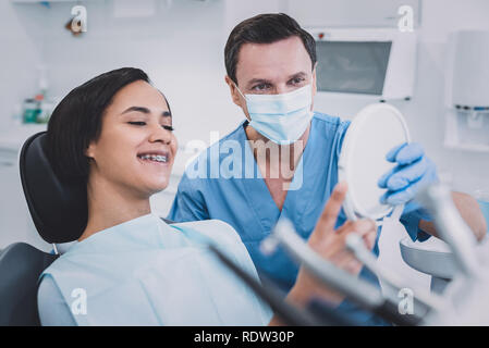 Heureux jeune patient contrôler ses dents en clinique