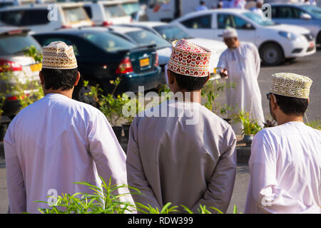 Trois hommes omanais épaules en vêtements traditionnels avec dishdasha et kuma Banque D'Images