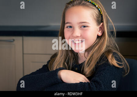 Portrait of beautiful smiling caucasian girl de 10 ans, assis à la maison, looking at camera