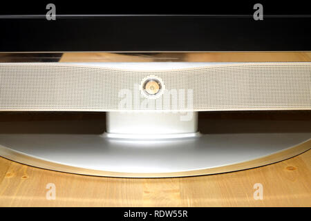 Bouton de mise sous tension sur la modernisation de la TÉLÉVISION À ÉCRAN LCD avec écran noir et blanc panneau d'argent avec beaucoup de petits trous sur la table en bois brun vue avant Banque D'Images