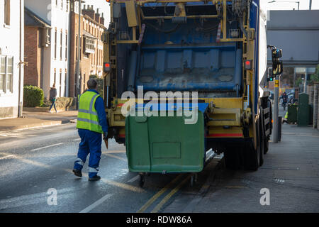 Camion benne camion gaspilleur ou collecte des déchets provenant d'un conteneur vert avec mécanisme d'exploitation des travailleurs bin conseil dans un gilet jaune Banque D'Images