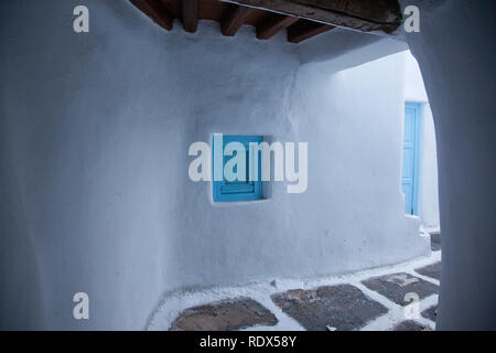 Rue étroite traditionnelle de Mykonos, avec des murs blancs et portes bleu Banque D'Images