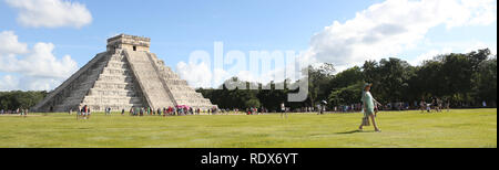 Chichen Itza pyramide et élégante jeune femme marche dans le coucher du soleil avec ciel assombri dramatique en arrière-plan Banque D'Images