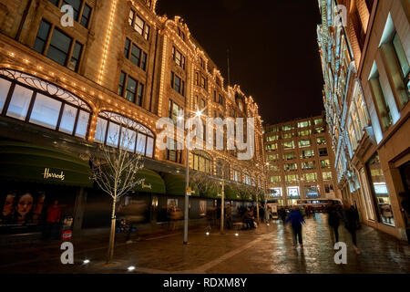 Vue extérieure du magasin Harrods à Londres la nuit durant l'hiver. Le trafic de nuit paysage de rue dans un jour pluvieux de UK Banque D'Images