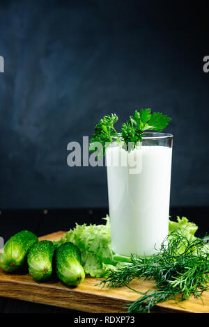 Plaine des yaourts frais avec les herbes de concombre sur fond sombre, froid boisson probiotique laitiers fermentés. Banque D'Images