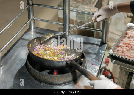 Chef professionnel et de l'incendie. La cuisson des légumes et des aliments sur un feu ouvert. Chef cuisine de style professionnel flambe. Il prépare le moule dans une casserole avec plate-F Banque D'Images