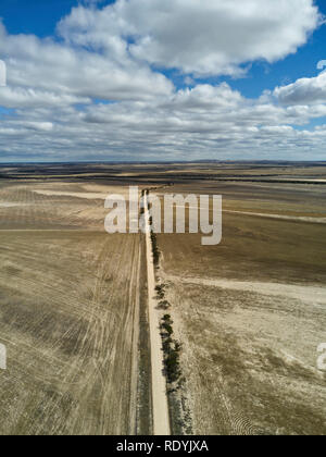 Vue aérienne de route rurale non scellées en passant par des champs de blé dans les pays près de l'écluse des dunes de sable du sud de la péninsule d'Eyre, en Australie Banque D'Images