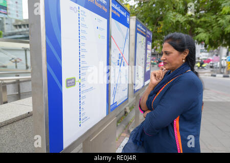 Belle mature femme indienne à la carte train à l'extérieur Banque D'Images