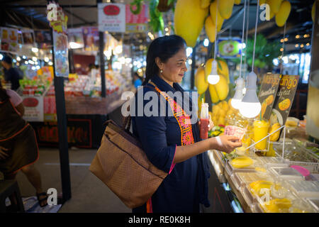 Belle mature femme indienne l'achat de fruits de mangue dans le marché Banque D'Images