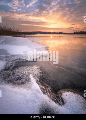 Paysage d'hiver paysage avec lac gelé et coucher du soleil à temps le soir en Finlande Banque D'Images