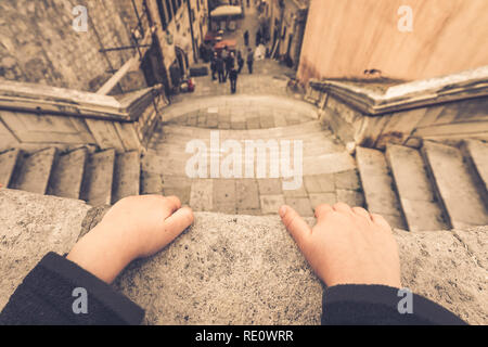 Dubrovnik, Croatie - Avril 2018 : portrait d'un petit garçon hands holding sur le balcon balustrade au-dessus de l'escalier dans la vieille ville de Dubrovnik Banque D'Images