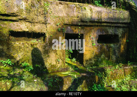 Ancienne en pierre sculptée dans le Temple de Gunung Kawi avec royal tombs illuminée par le soleil du soir et principale du chemin à travers les jungles à Bali, Indonésie Banque D'Images